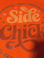 video showcase of orange Side Chick Thanksgiving Tee with bold Side Chick foodie graphic, highlighting comfort and holiday humor