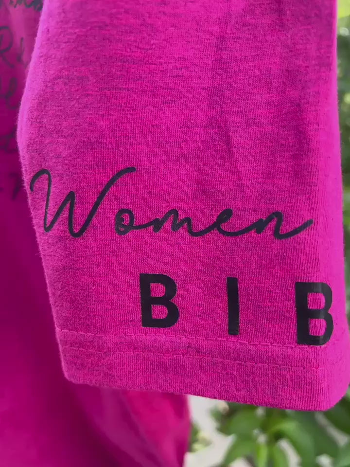 close up of sleeve of graphic on Berry-colored Woman of the Bible graphic tee displayed outdoors on hanger