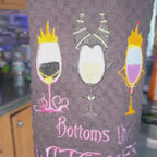 Video of a Black towel with three wine glasses Halloween themed that says Bottoms Up Witches