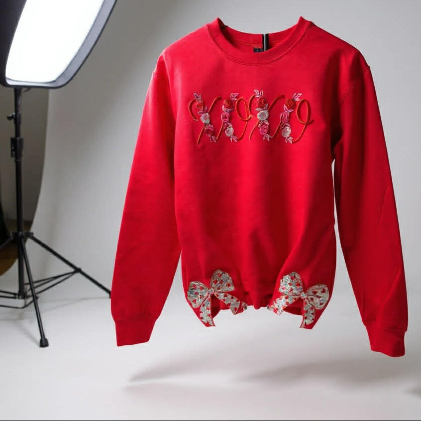 Red sweatshirt with floral designs on a white background