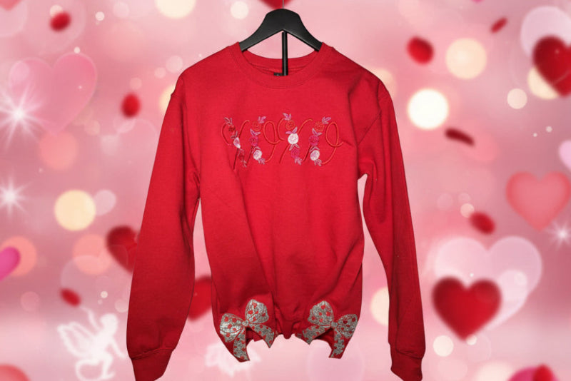 Red sweatshirt with floral designs on a white surface