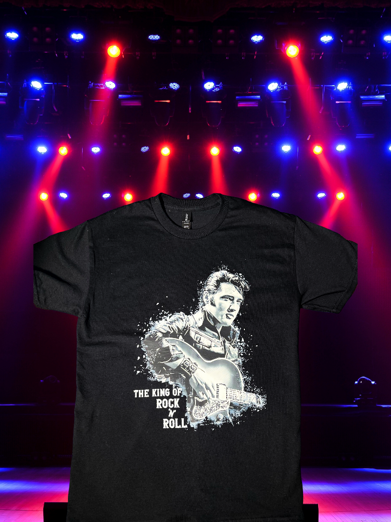 Black Elvis Presley graphic t-shirt with bold guitar design for fans displayed under concert lights.