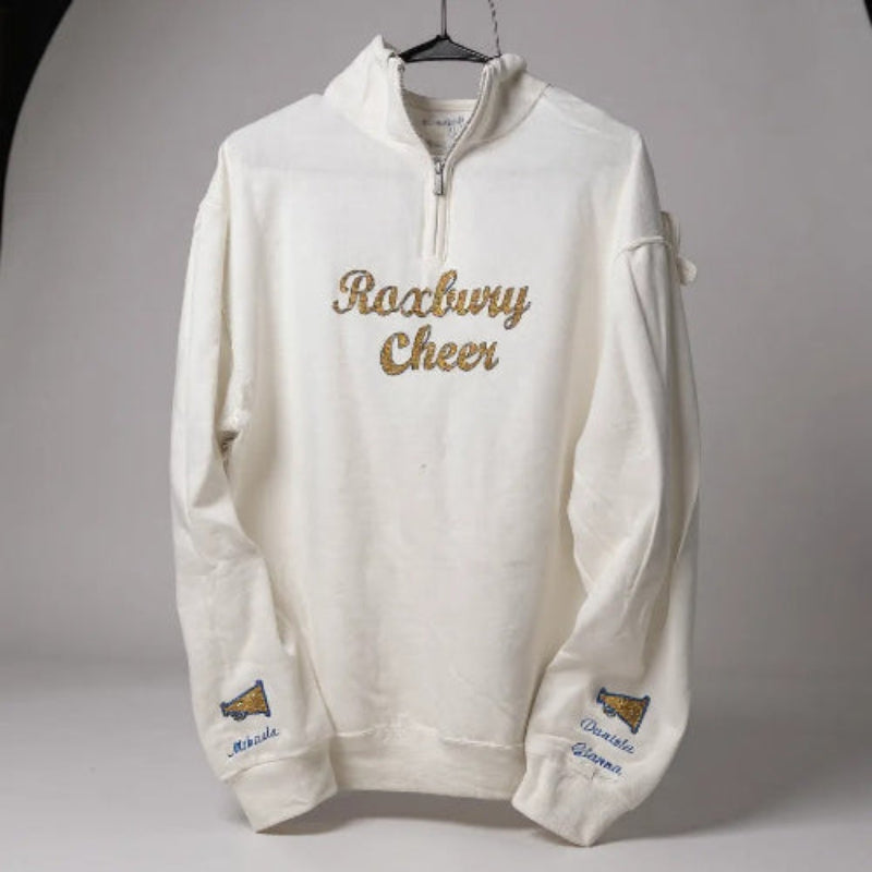White sweatshirt with 'Roxbury Cheer' text and names with a megaphone on the sleeves on a gray background