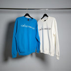 Blue and white sweatshirts with text on hangers against a gray background