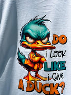 Close-up of duck cartoon with folded arms on Do I Look Like I Give a Duck on white shirt.